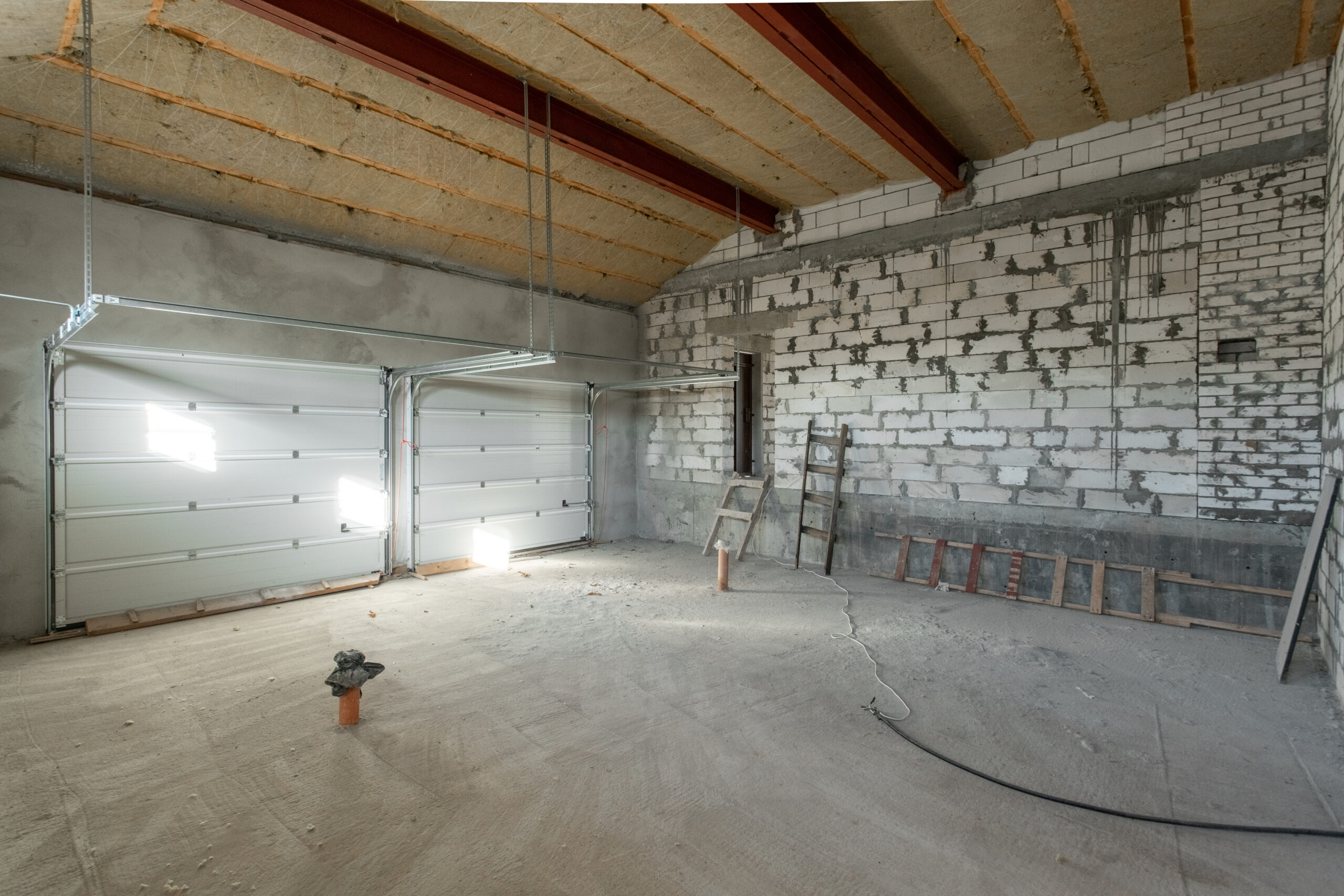 Large garage for two cars with of the gate. overhaul and reconstruction. Working process of warming inside part of roof. House or apartment is under construction, remodeling, renovation, restoration. Large garage for two cars with of the gate. overhaul and reconstruction. Working process of warming inside part of roof. House or apartment is under construction, remodeling, renovation, restoration.