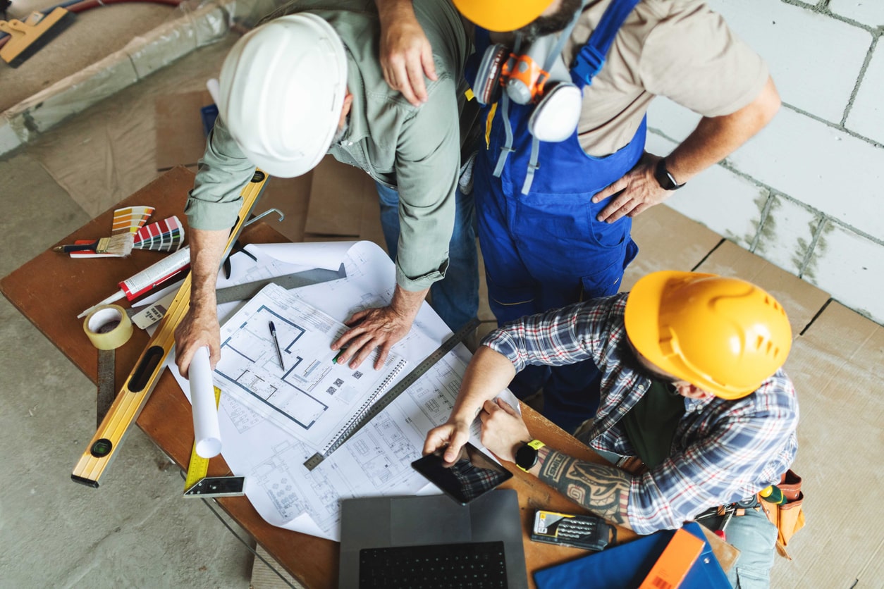 tradespeople reviewing building plans